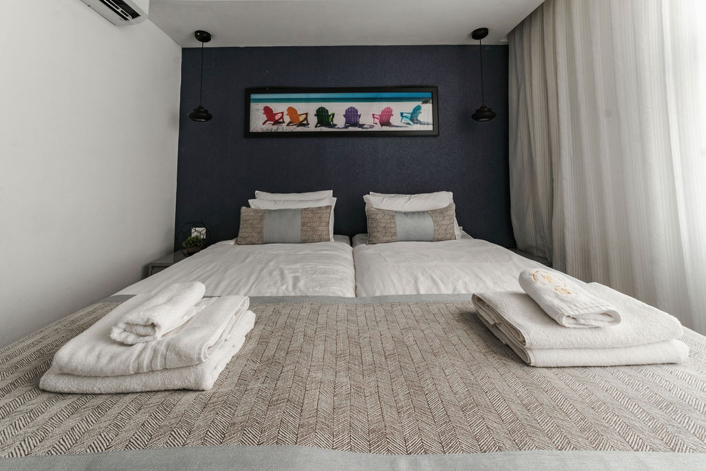 Lits jumeaux et tête de lit bleue à l'Hotel Kikar Netanya
